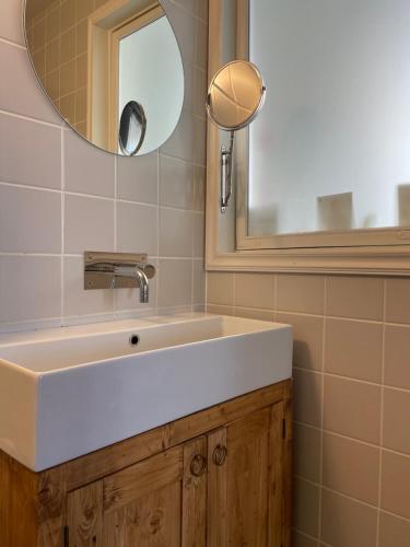 a bathroom with a white sink and a mirror at Stationmaster's studio in Porvoo
