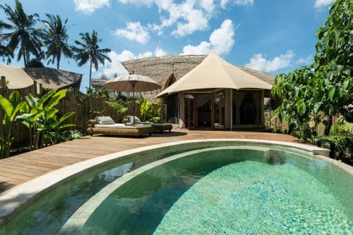 a swimming pool in the backyard of a villa at Sandat Glamping Tents in Ubud