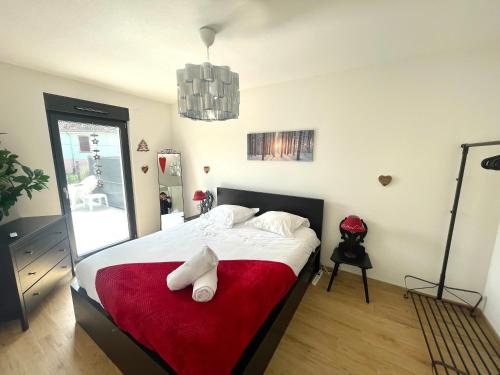 une chambre avec un grand lit avec une couverture rouge dans l'établissement Magnifique 2 pièces, tout équipé, terrasse privée, à Colmar
