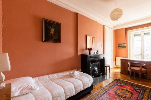 - une chambre avec des murs orange, un lit et un bureau dans l'établissement DIFY Presqu ile Bellecour, à Lyon