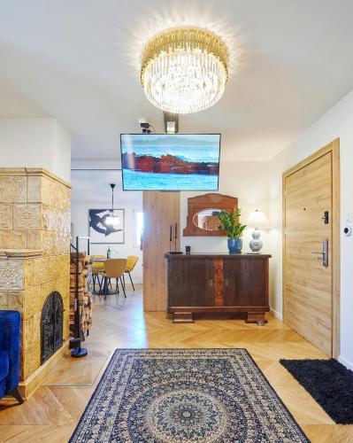 a living room with a fireplace and a chandelier at Apartament Bursztynowy Piec in Hel