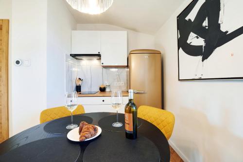 a table with a bottle of wine and a plate of food at Apartament Bursztynowy Piec in Hel
