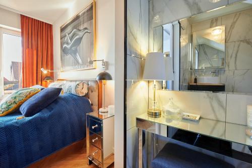 a bedroom with a blue bed and a mirror at Apartament Bursztynowy Piec in Hel