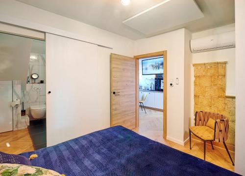 a bedroom with a purple bed and a bathroom at Apartament Bursztynowy Piec in Hel