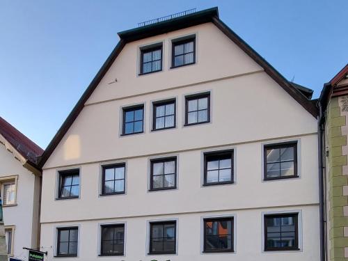a white building with black windows at Ferienwohnung Am Schloss in Sigmaringen