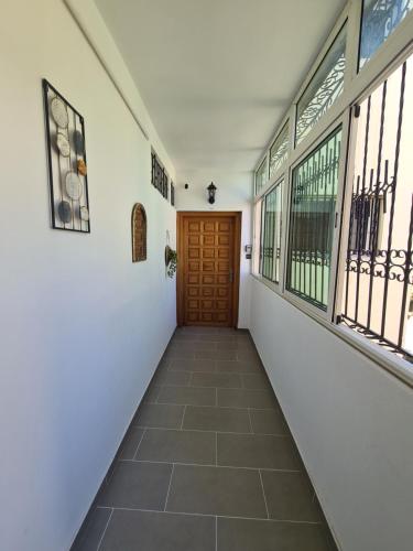 a hallway with a wooden door and windows at Dar Babou in Rabat