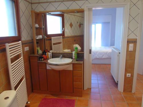 ein Bad mit einem Waschbecken und einem Spiegel in der Unterkunft Villa avec piscine et vue panoramique mer in Roses