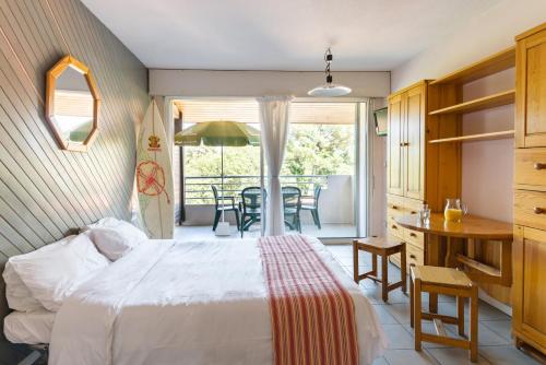 オスゴールにあるRésidence du Parc Hossegorのベッドルーム1室(ベッド1台、テーブル、椅子付)