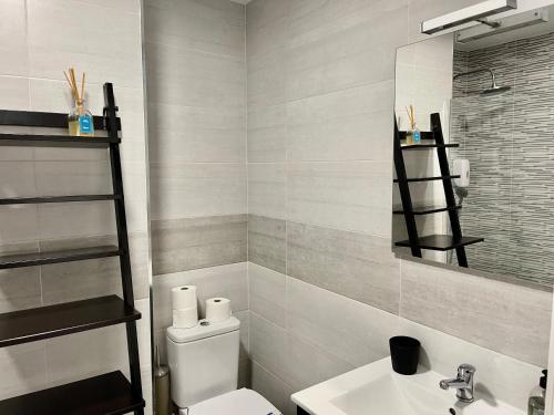 bagno con servizi igienici, lavandino e specchio di Don Paco Modern Loft a Marbella