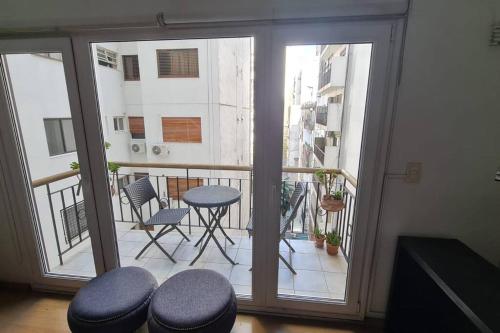 een kamer met een balkon met een tafel en stoelen bij Duplex en el Corazón de Recoleta in Buenos Aires