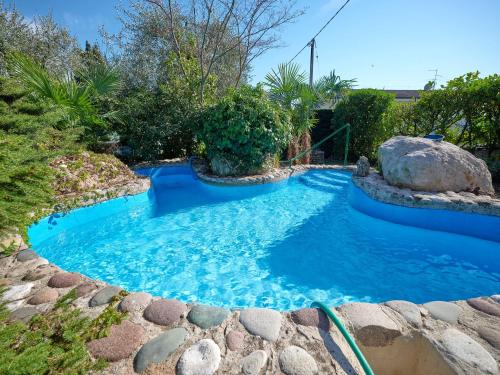 ein kleiner Pool mit einem Felsen und blauem Wasser in der Unterkunft ApartmentsGarda - Residenza Bouganville in Garda