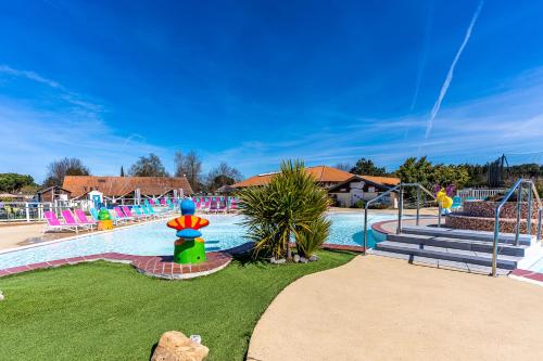 un parc aquatique avec une grande piscine et une aire de jeux dans l'établissement Mobilehome familial, à Gastes