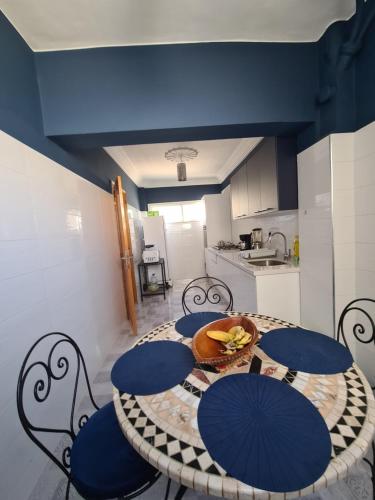 a kitchen with a table with blue tables and chairs at Dar Babou in Rabat