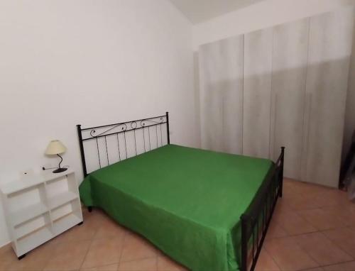 a bedroom with a bed with a green sheet at Casa Santoreggia Olbia, Porto Istana, Murta Maria in Murta Maria