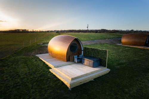 a wooden structure sitting on the grass in a field at Endrick Escape - Luxury Glamping in Gartness