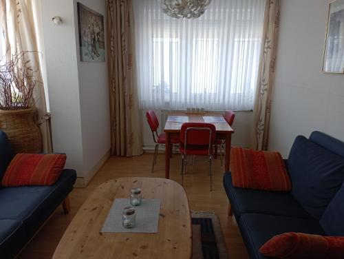 a living room with a table and a blue couch at Ferienwohnung Petersen I in Büdelsdorf