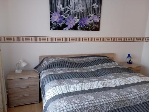 a bedroom with a bed and a picture on the wall at Ferienwohnung Petersen I in Büdelsdorf