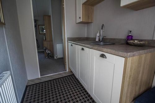 a kitchen with a sink and a counter top at Stunning 4 Berth Lodge With Decking At Breydon Water In Norfolk Ref 10094b in Belton