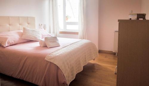 - une chambre avec un lit doté d'oreillers et d'une fenêtre dans l'établissement Apartamento O SALEIRO, à Padrón