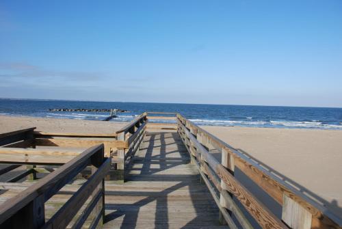 a wooden boardwalk leading to the beach at Historic Beach Side Getaway - Pet friendly, WiFi cottage in Norfolk