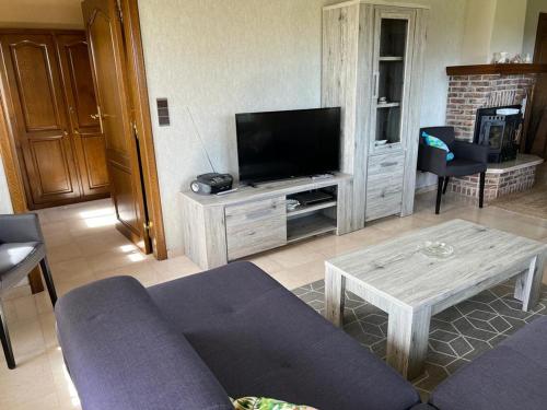a living room with a couch and a tv at Huize Liesanne in Bredene