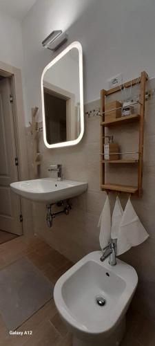 een badkamer met een wastafel, een toilet en een spiegel bij Trieste Mia Rooms in Trieste
