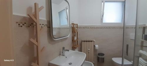 y baño con lavabo, espejo y aseo. en Trieste Mia Rooms en Trieste