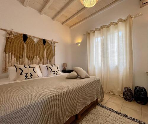 a bedroom with a bed and a window at Infinity View Villas Mykonos in Kalo Livadi