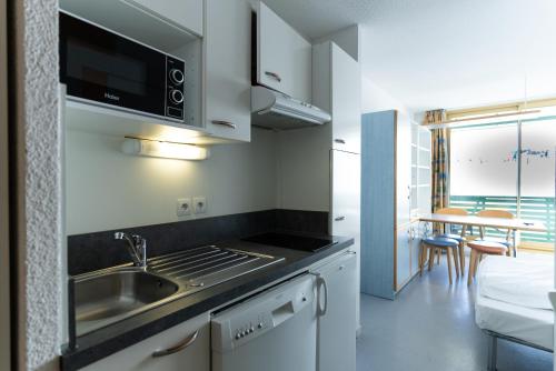 a kitchen with a sink and a microwave at Résidence Azureva Piau Engaly in Aragnouet