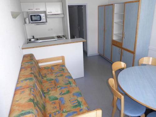 a kitchen and a table with a couch in a room at Résidence Azureva Piau Engaly in Aragnouet