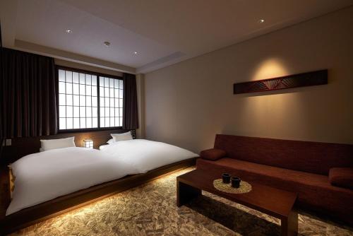 a hotel room with a bed and a couch at Minn Kanazawa in Kanazawa