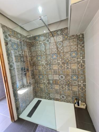 a shower with a glass door in a bathroom at Dar Babou in Rabat