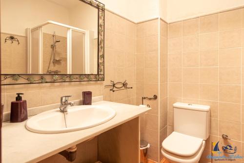 uma casa de banho com um lavatório, um WC e um espelho. em El Velero Sotillo Cactus Piscina em San José