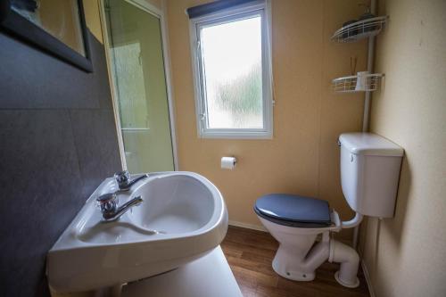 a bathroom with a sink and a toilet and a window at 6 Berth Caravan Nearby Great Yarmouth In Norfolk Ref 10022rp in Belton