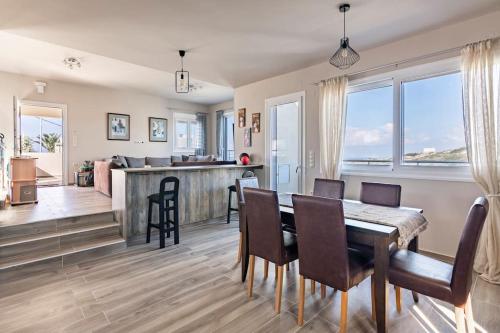 uma sala de jantar e cozinha com mesa e cadeiras em Cosy, Sea View villa ''Andreas'' close to beach em Ligaria