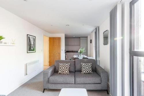 ein Wohnzimmer mit einem Sofa und einem Tisch in der Unterkunft Stylish 1 Bedroom Apartment by BOLD Apartments in Liverpool