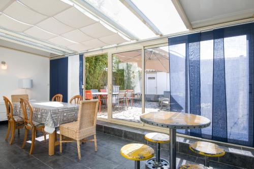 une véranda avec une table et des chaises ainsi qu'une terrasse dans l'établissement LA SUITE GRANDE MAISON AU COEUR DU VILLAGE DE LA FLOTTE EN RÉ, à La Flotte