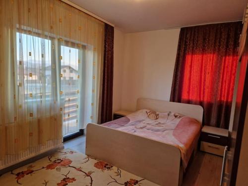a bedroom with a bed and a large window at Casă și curte confortabilă in Braşov