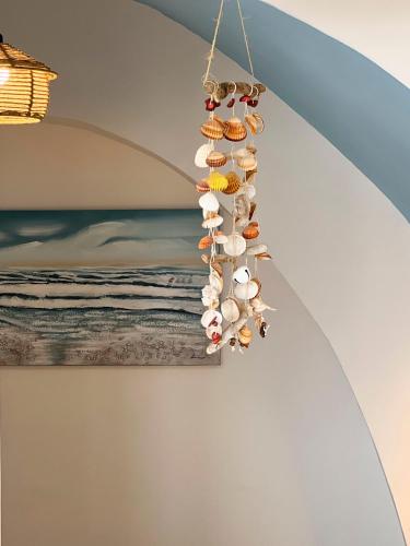 a group of shells hanging from a ceiling at Calilla house by Procida Reserve in Procida
