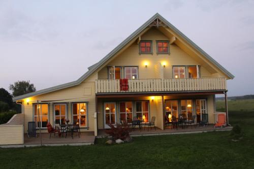 a large house with a porch with tables and chairs at Ferienhaus Norway in Wittenbeck