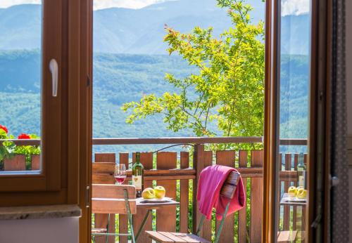 a room with a balcony with a table and a window at Dissertorihof in Caldaro