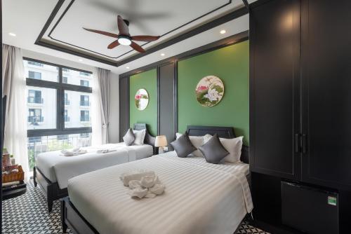 two beds in a room with green walls at Le Palmier Phu Quoc Hotel - Free Shuttle To Grand World in Phu Quoc