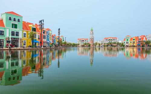 a large body of water with colorful houses and buildings at Le Palmier Phu Quoc Hotel - Free Shuttle To Grand World in Phu Quoc