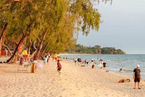 a group of people on a beach near the water at Le Palmier Phu Quoc Hotel - Free Shuttle To Grand World in Phu Quoc