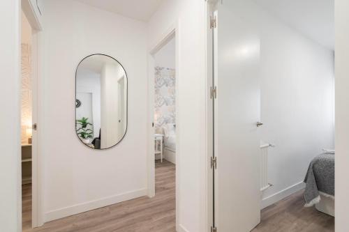um quarto branco com um espelho e um quarto em For you Rentals Moderno apartamento cerca ZOO y del Parque de Atracciones CEB76 em Madri