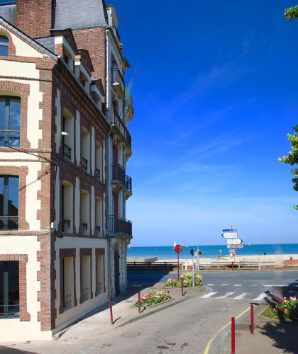 - un bâtiment situé dans une rue à côté de la plage dans l'établissement Résidence LA VAGUE- Appartements Grand Confort -Vue mer - 2 à 6 personnes, à Houlgate