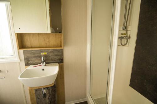a bathroom with a sink and a shower at Modern Caravan At Caldecott Hall With Decking In Norfolk, Sleeps 8 Ref 91068c in Great Yarmouth