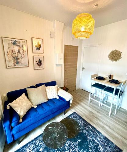 un salon avec un canapé bleu et une table dans l'établissement Escale bohème - Terrasse en centre-ville - Gare, à Amiens