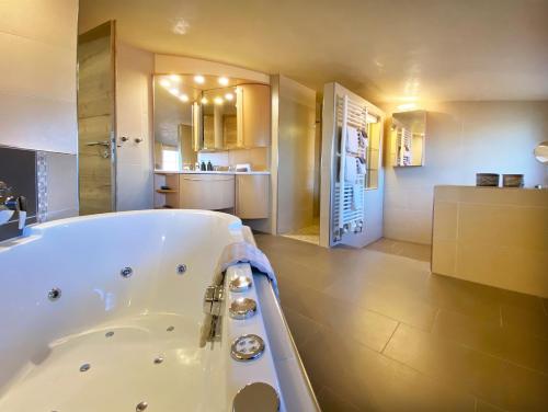 a large bathroom with a tub and a kitchen at OlfenLodge in Olfen
