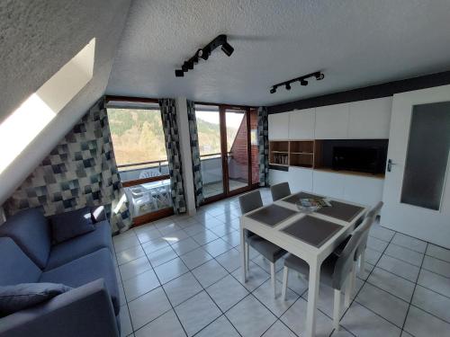 un salon avec une table et un canapé bleu dans l'établissement Appartement T2 45m² avec terrasse - 4/6 personnes, à Le Mont-Dore